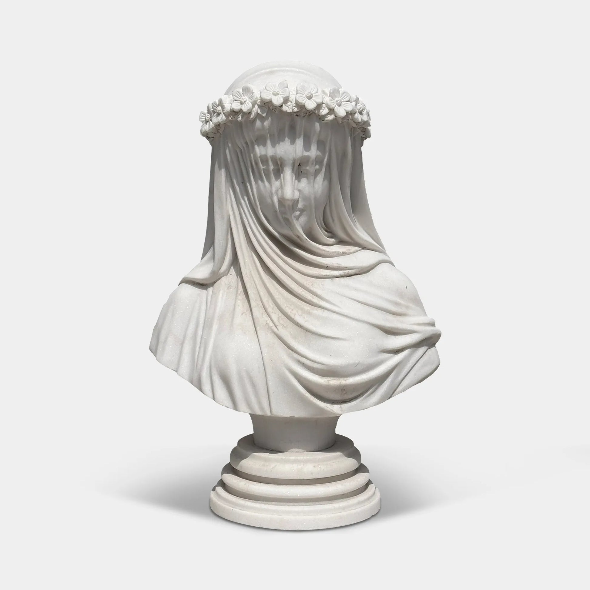 White marble veiled bust sculpture with flower crown in a luxury bedroom beside elegant classic furniture.