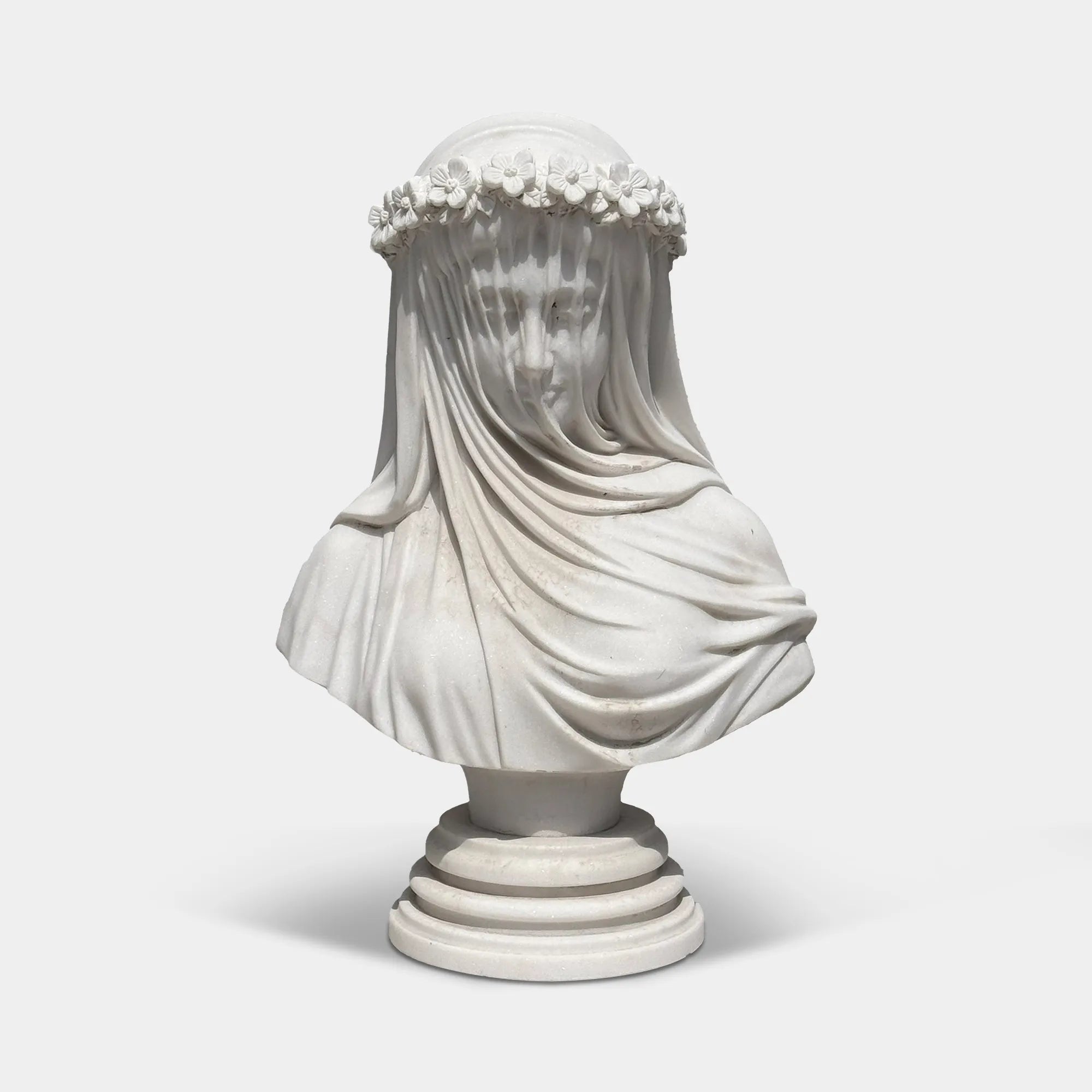 White marble veiled bust sculpture with flower crown in a luxury bedroom beside elegant classic furniture.