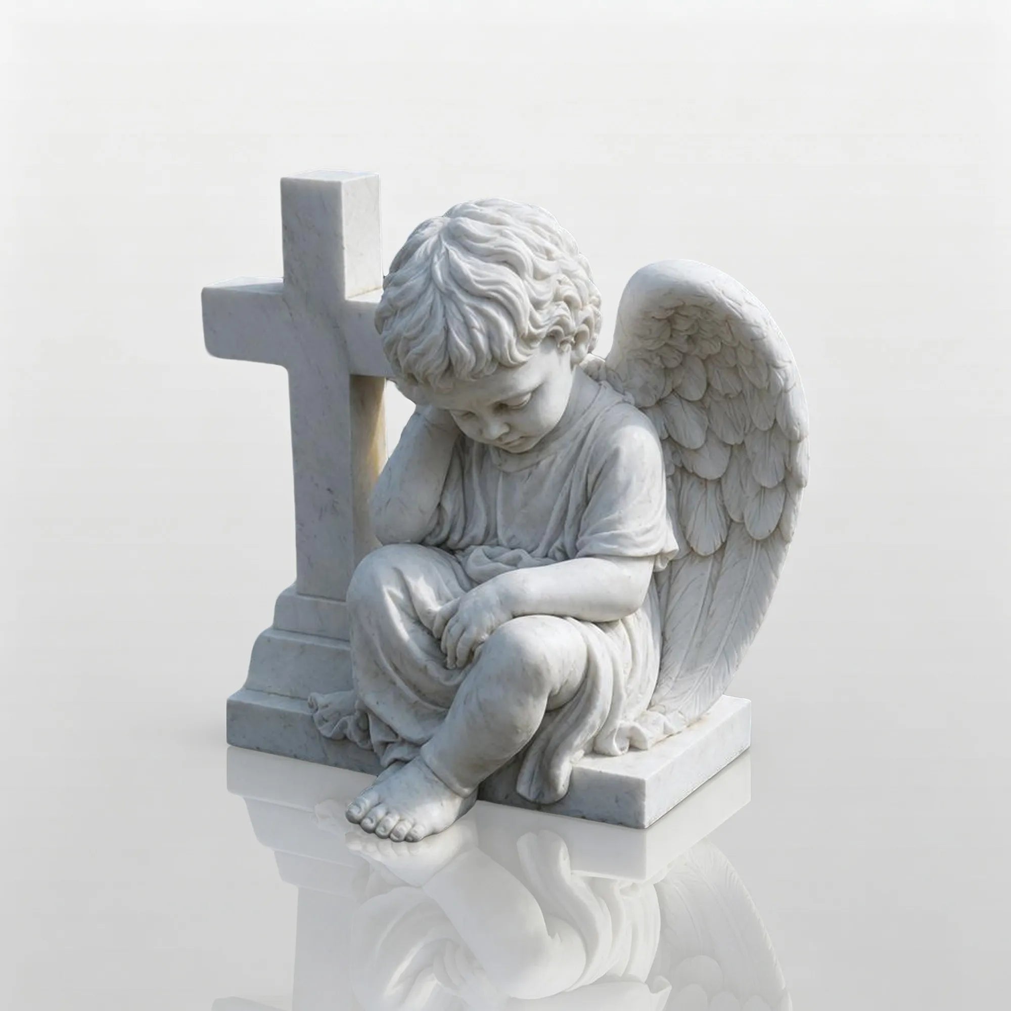 White marble seated child angel sculpture leaning against a cross on a black granite base for cemetery grave and church memorial garden