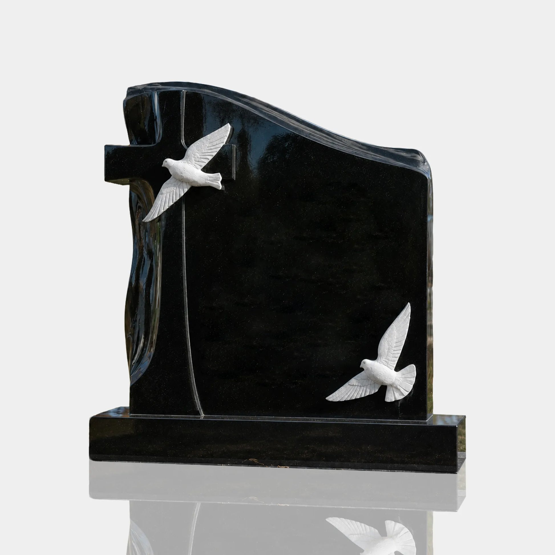 Black marble memorial headstone with white carved doves and cross for cemetery headstone and family grave.