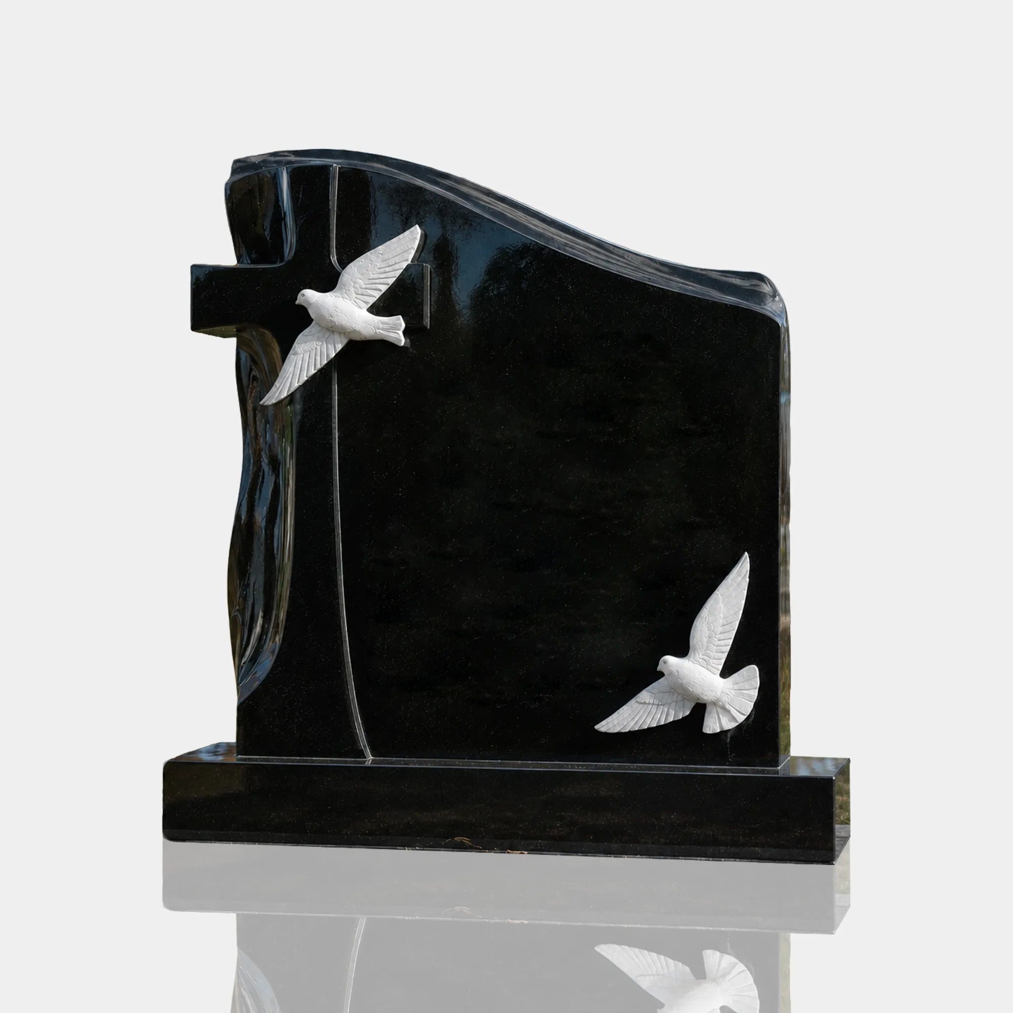 Black marble memorial headstone with white carved doves and cross for cemetery headstone and family grave.
