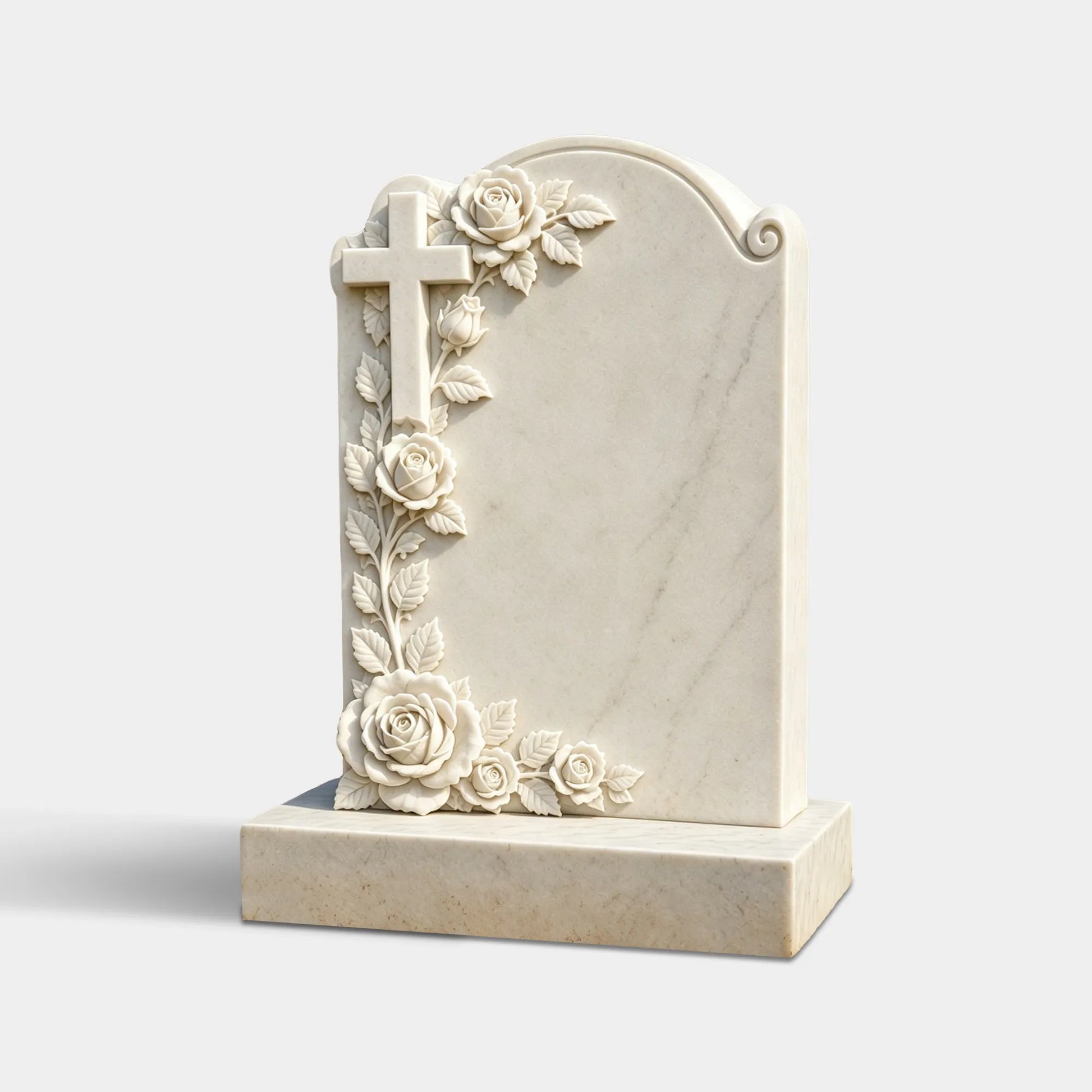 White marble Christian headstone with an arched top, carved cross, climbing roses, leaves, blank inscription panel, and rectangular base in an autumn cemetery.