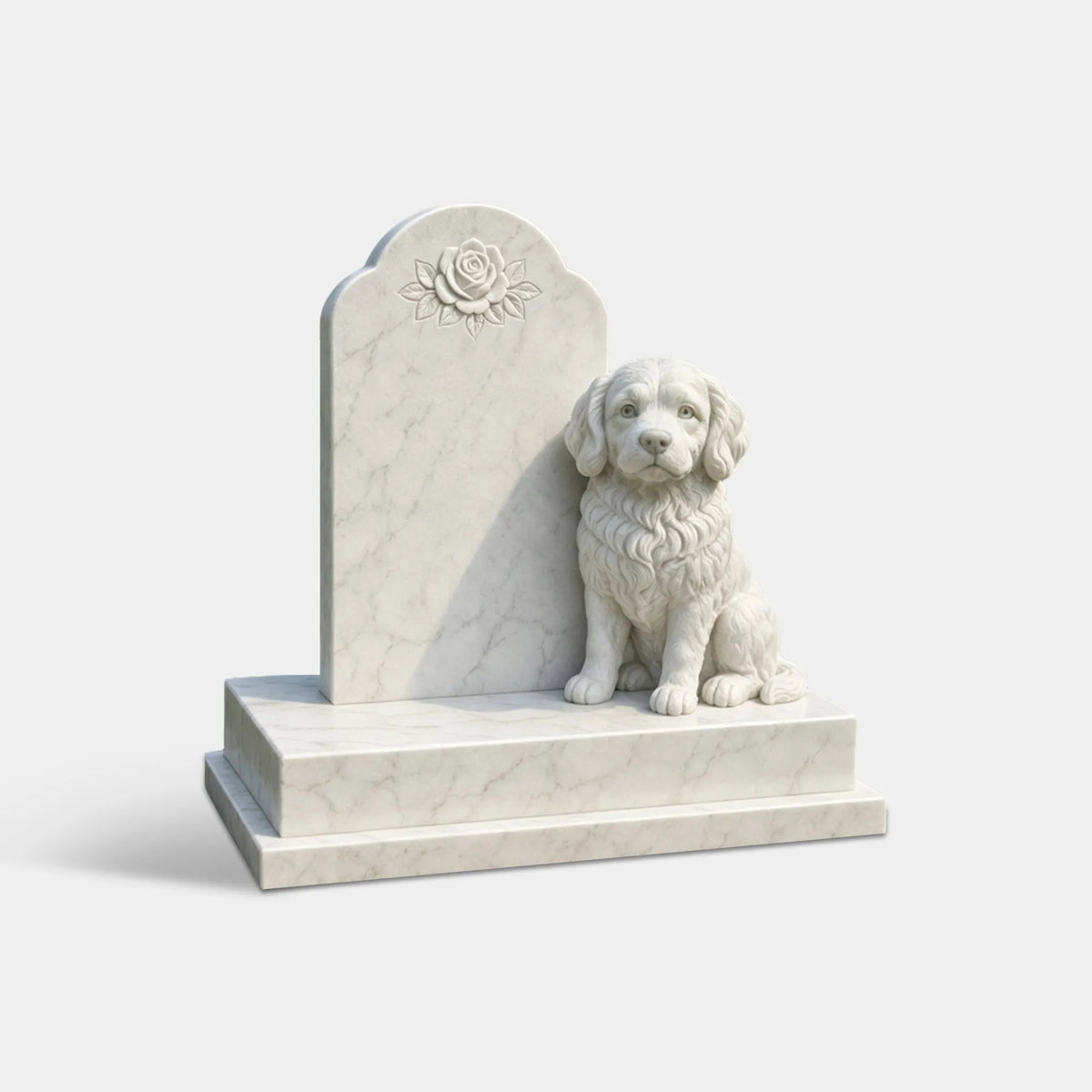 White marble pet memorial sculpture with a carved seated dog, rose-decorated headstone in a cemetery lawn.
