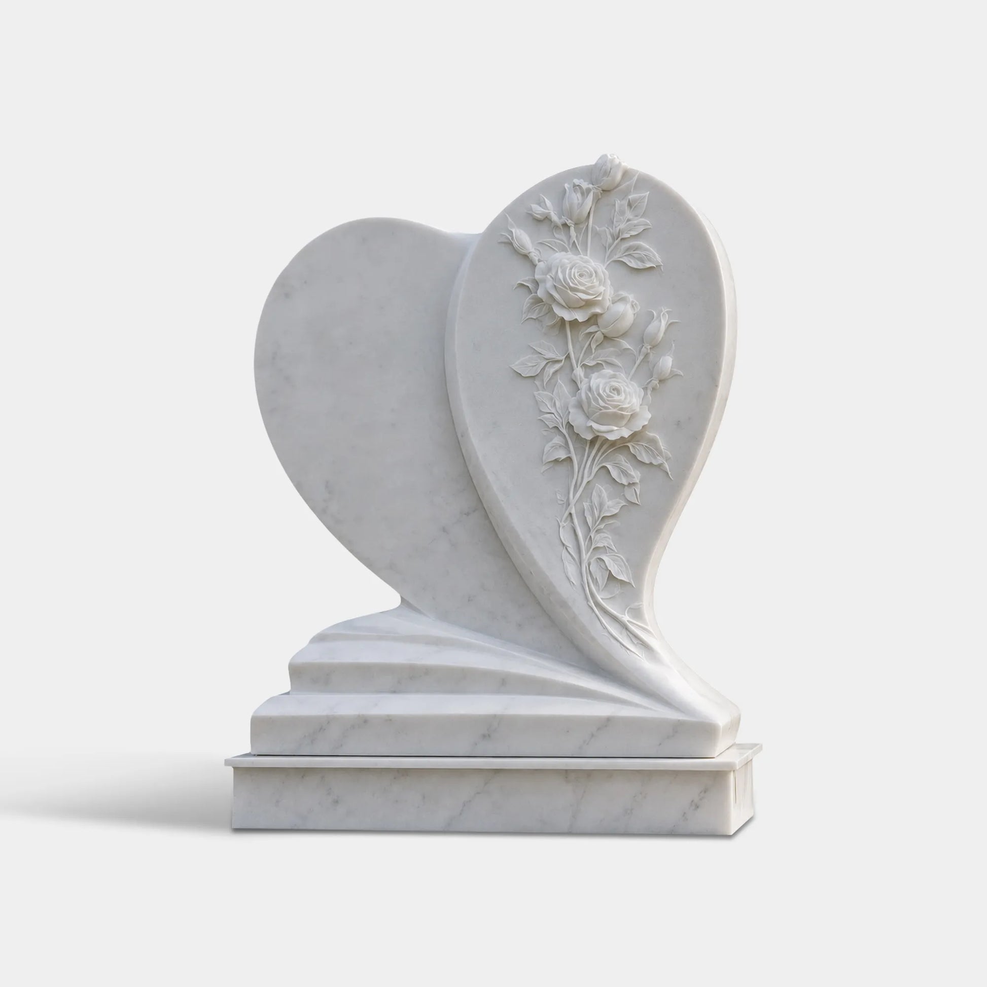 White marble heart headstone stands within cemetery.