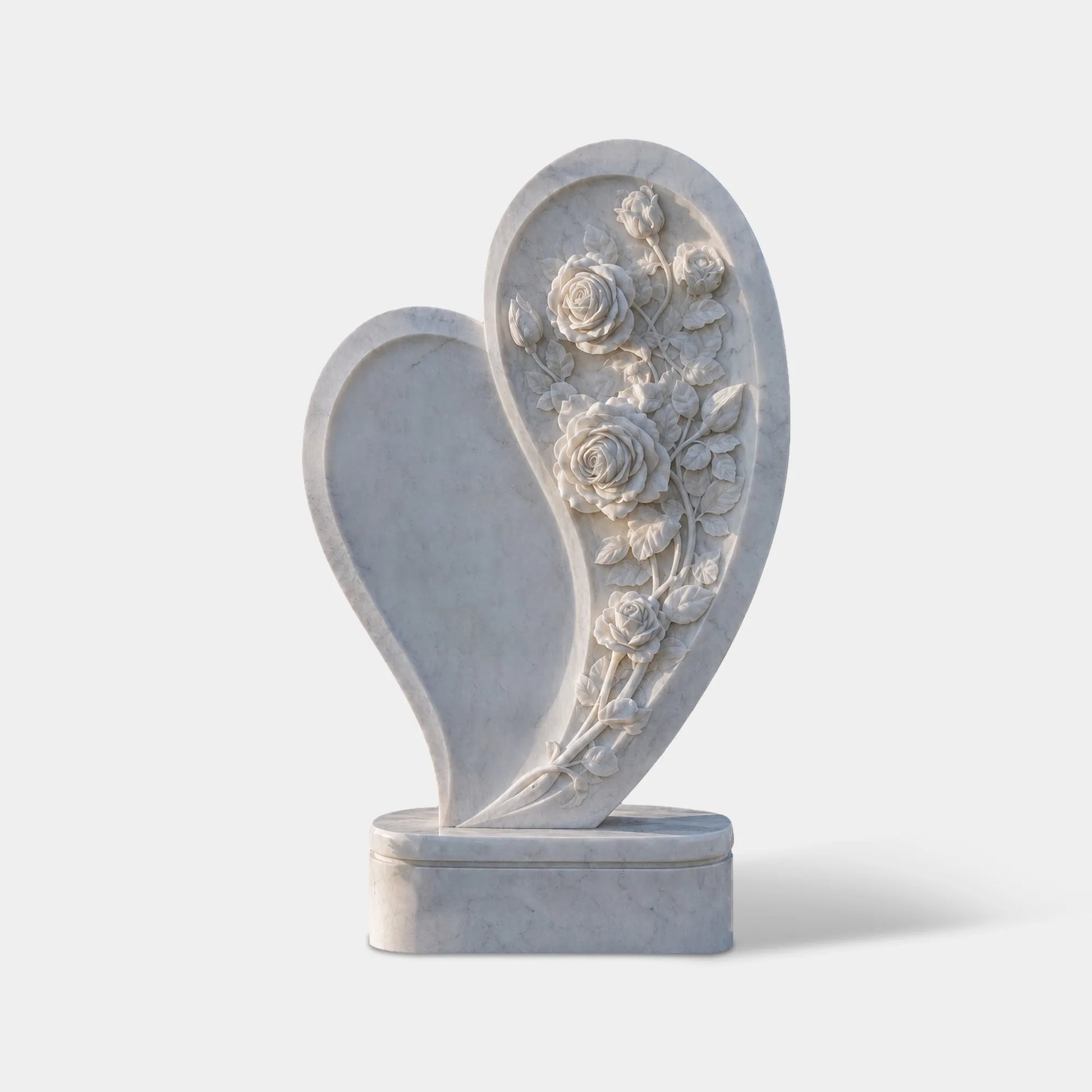 White marble heart tombstone is placed in a cemetery.