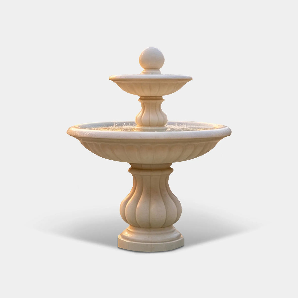 A white marble fountain stands in the courtyard of an elegant stone mansion.