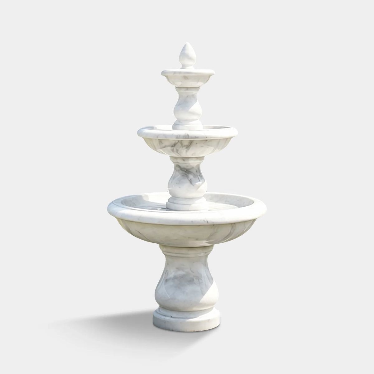 White marble three-tier fountain with rounded basins in a landscaped front garden