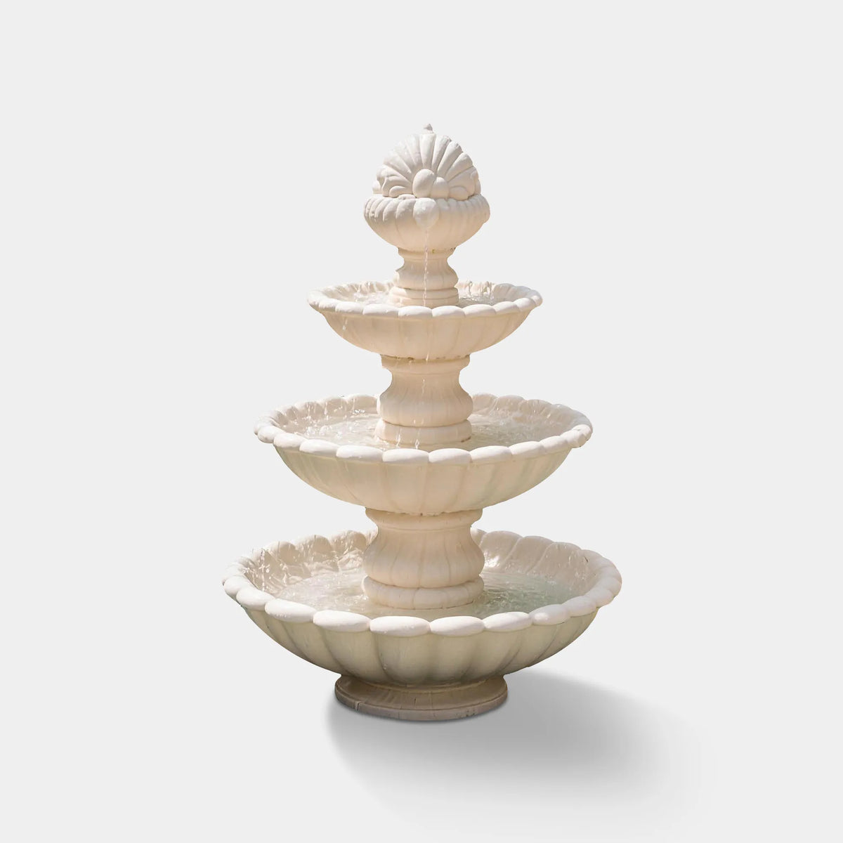 A white marble fountain sits inside a swimming pool in a luxury residential backyard.