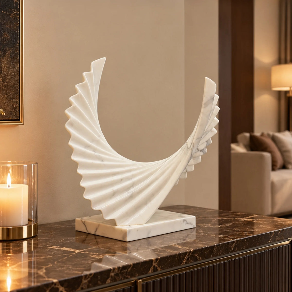 A marble wings sculpture sits on a dark marble console table in a warm living room.