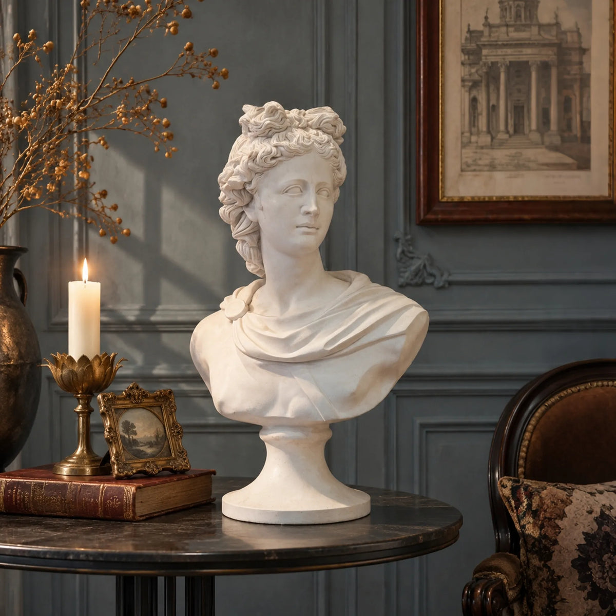 A marble Apollo bust rests on a round side table with candle decorations in a vintage room.