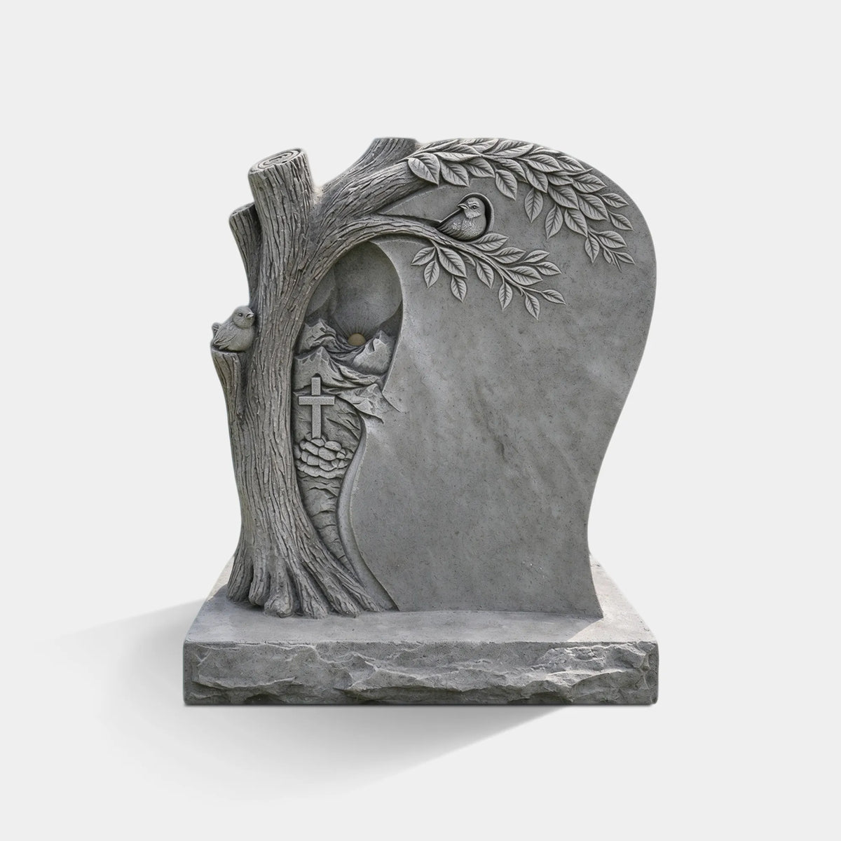 A marble memorial headstone with tree, cross and sun details stands on grass in a cemetery.