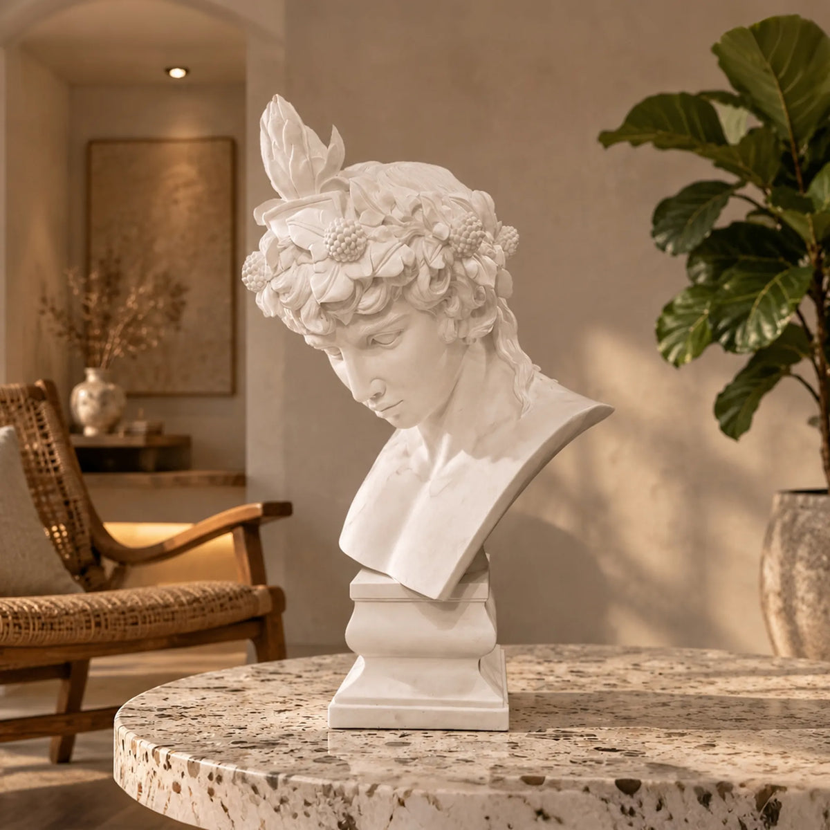 A marble Antinous bust sits on a speckled round stone table inside a warm room.