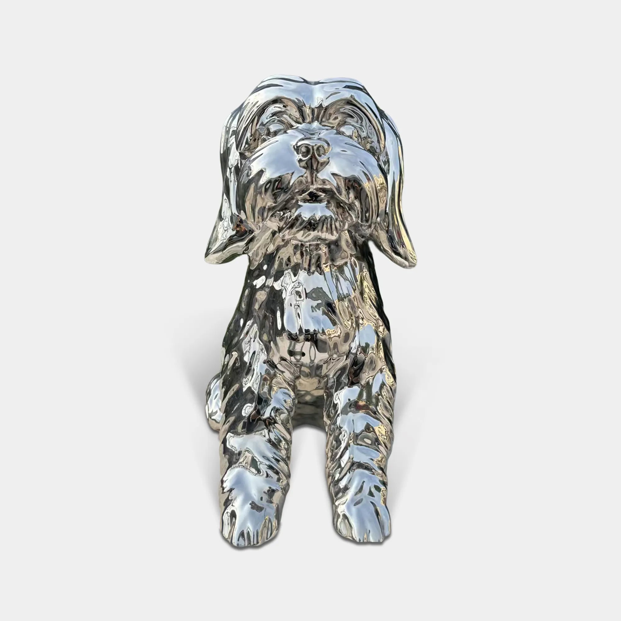 Polished stainless steel seated dog sculpture with reflective surface and detailed fur texture in modern interior with wood wall panels and marble floor