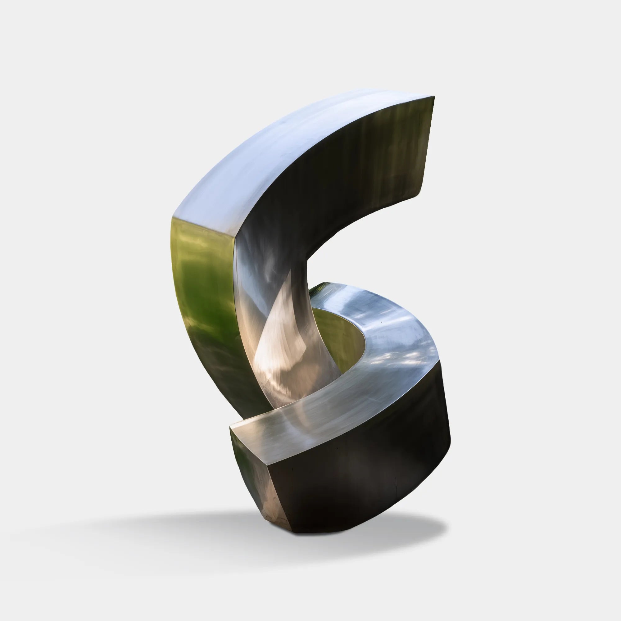 Abstract stainless steel sculpture with curved flowing form in polished finish in a garden near an office building.