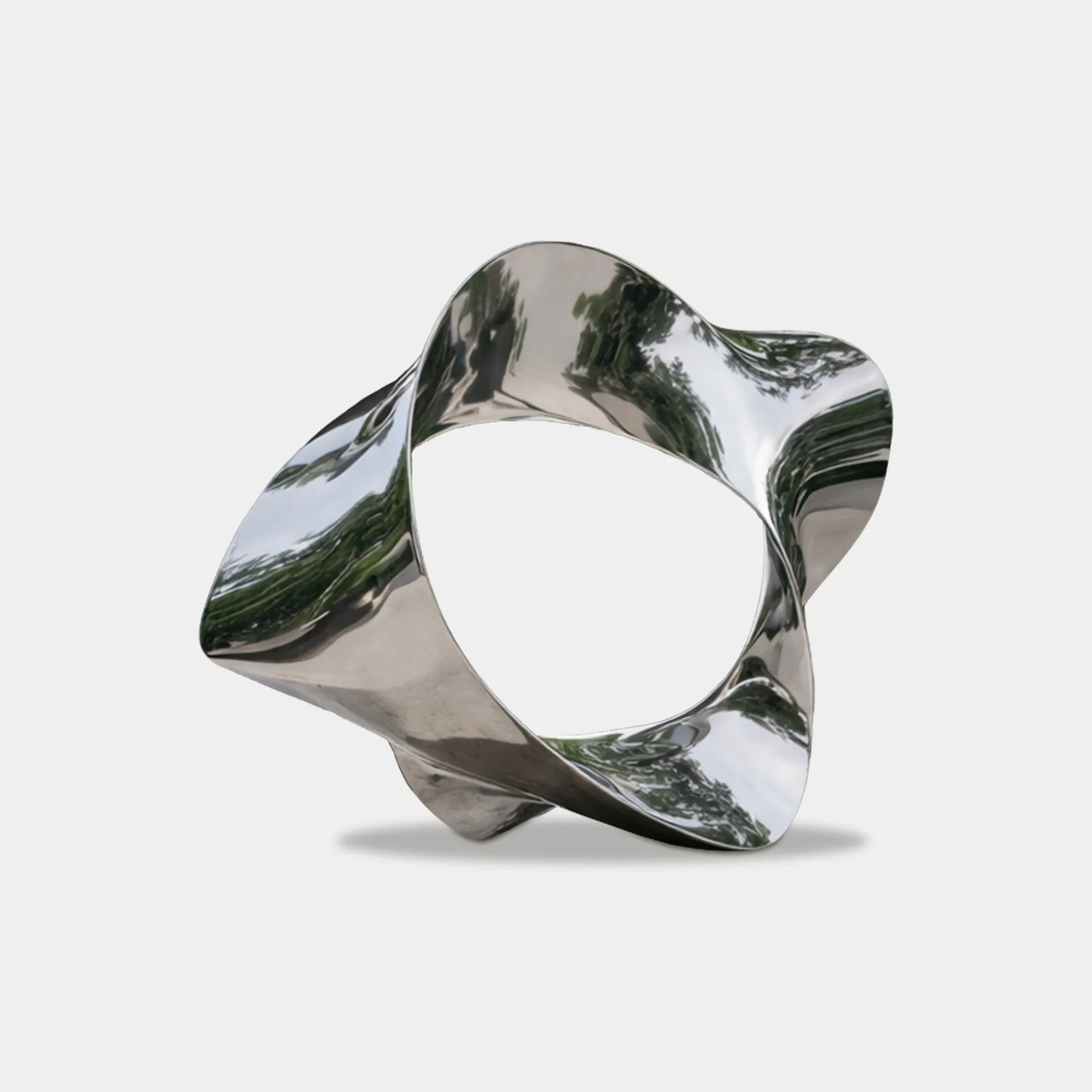 Mirrored stainless steel star shape sculpture in a modern villa courtyard with trees and concrete architecture.
