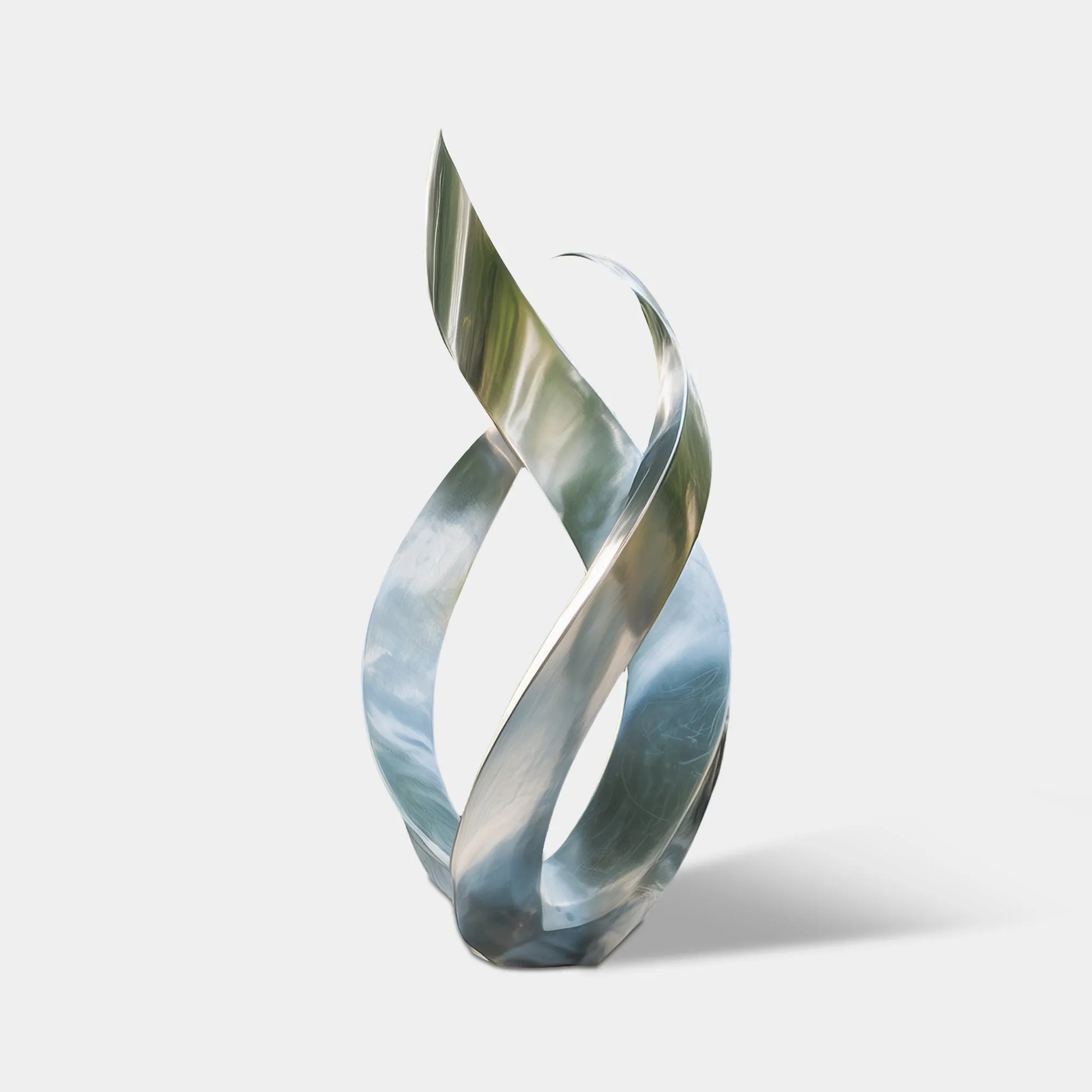 Silver abstract stainless steel sculpture with twisting ribbon forms in a modern villa courtyard.