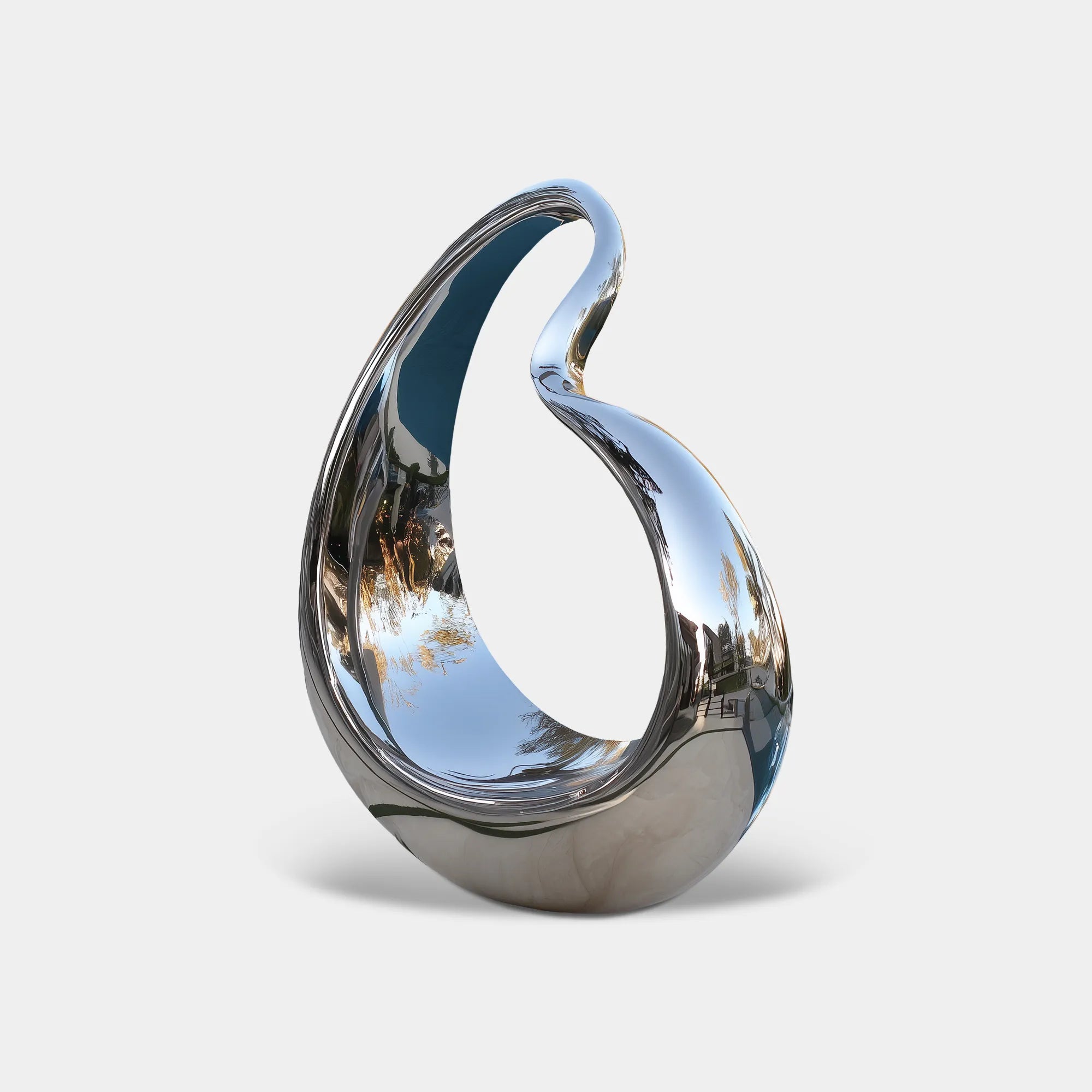 Polished silver stainless steel sculpture with an open teardrop form beside a swimming pool in a landscaped garden