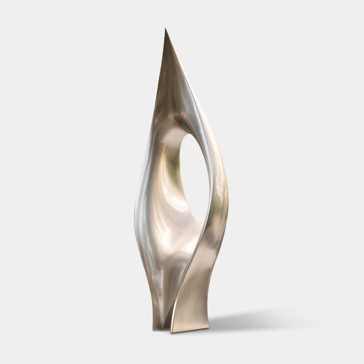 Tall stainless steel sculpture with a pointed flowing form and open center beside a contemporary villa.